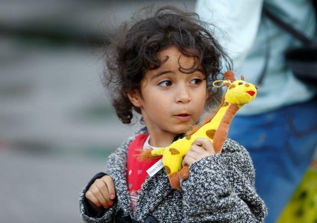 Child seeking asylum with giraffe toy
